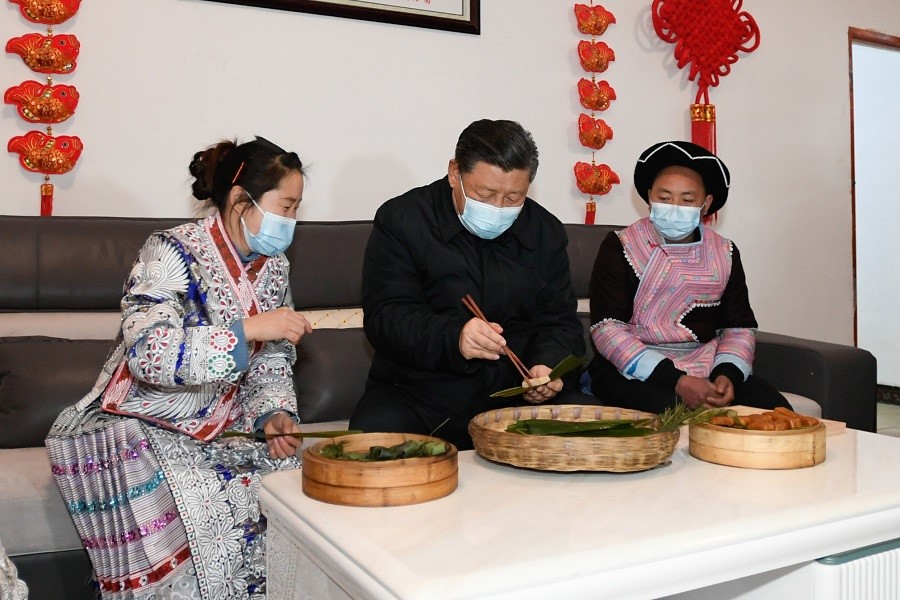 2021年2月3日下午，習(xí)近平在貴州畢節(jié)市黔西縣新仁苗族鄉(xiāng)化屋村苗族村民趙玉學(xué)家，同一家人邊聊家常邊制作當(dāng)?shù)貍鹘y(tǒng)節(jié)日食品黃粑。新華社記者 李學(xué)仁 攝