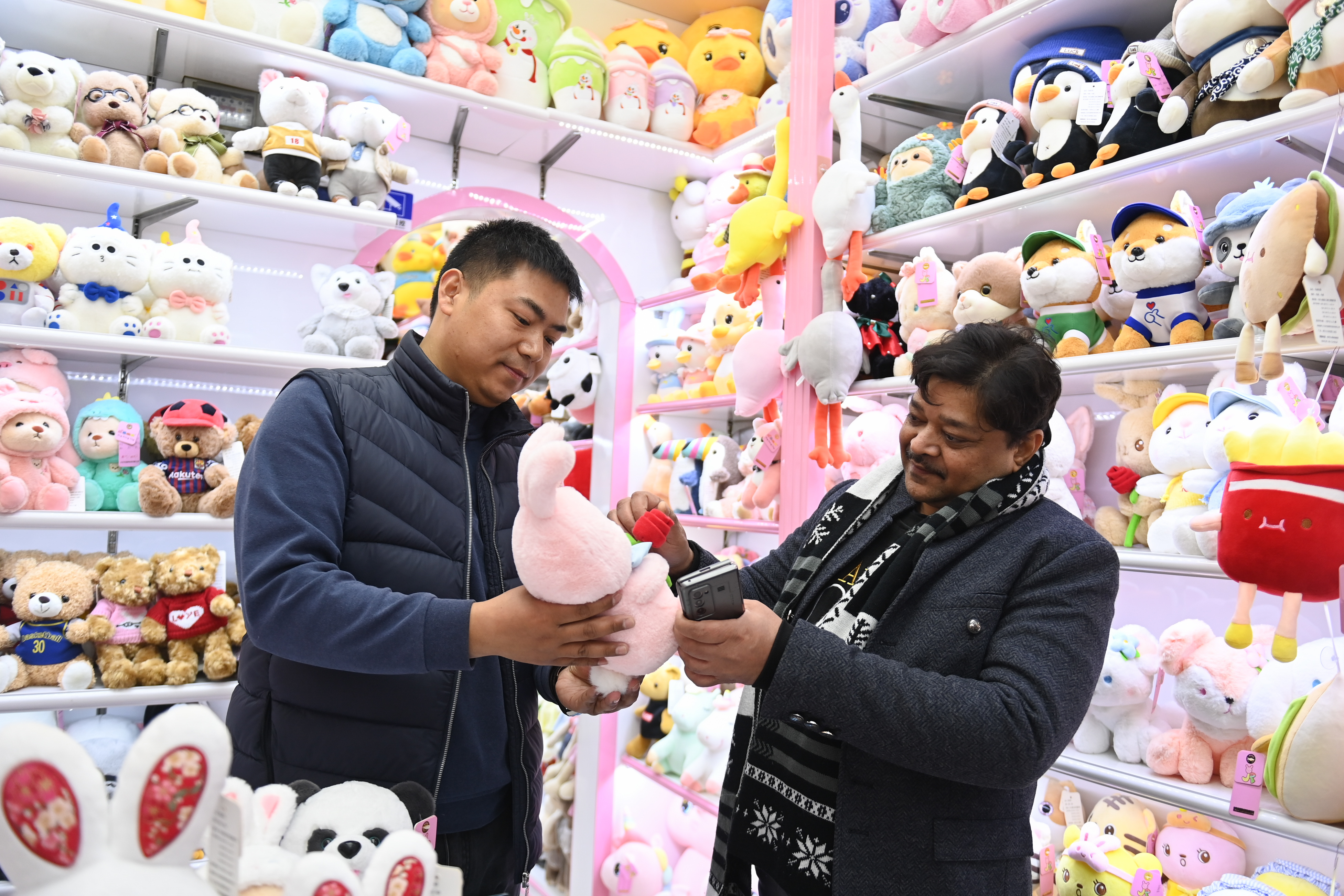 2023年2月2日，來(lái)自印度的客商（右）在義烏國(guó)際商貿(mào)城的一家玩具店鋪內(nèi)選購(gòu)。